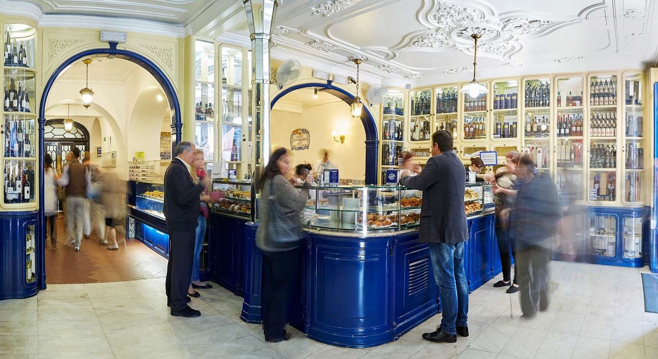 The blue-and-white counter room of Pastéis de Belém under stucco ceilings